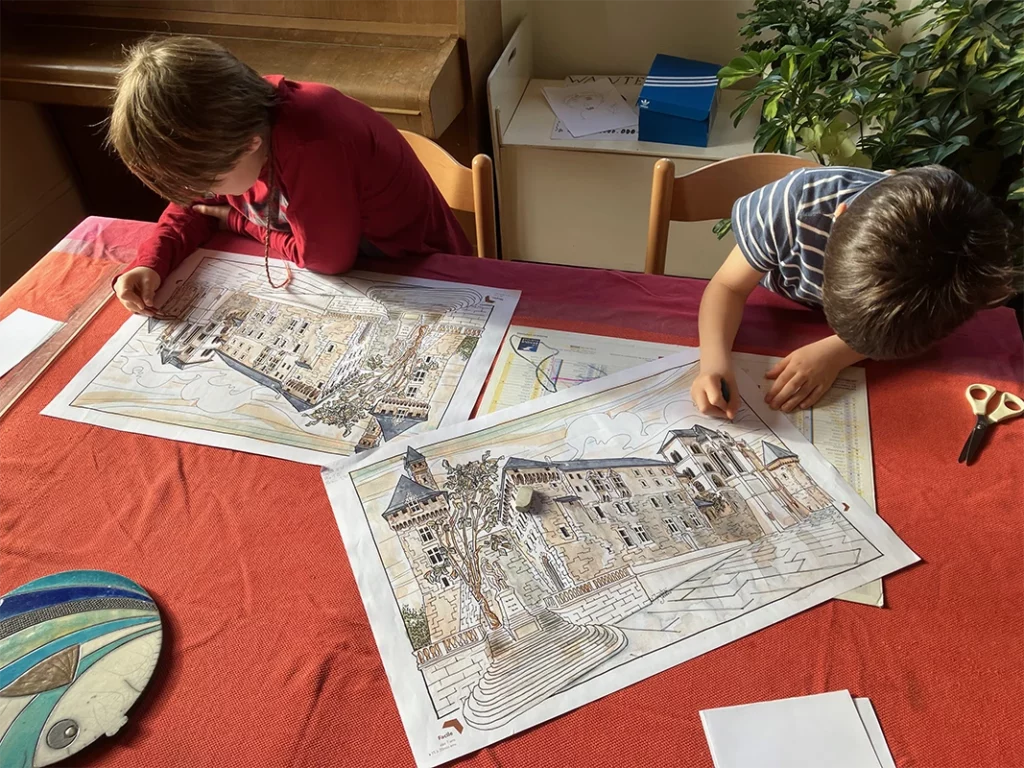 Deux enfants jouent au labyrinthe sur une table.